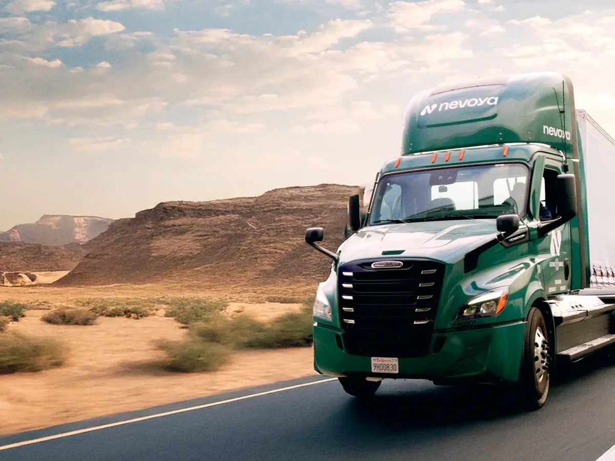 Nevoya truck in green livery driving along a desert highway